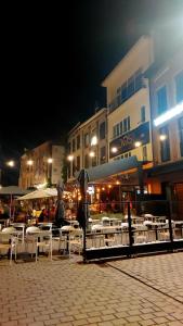 a group of tables and chairs with umbrellas at night at Maison Marthe in Sint-Truiden