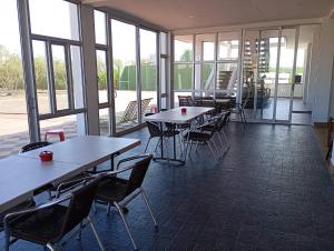 a dining room with tables and chairs and windows at Astilleros Santa Veronica in Santa Verónica