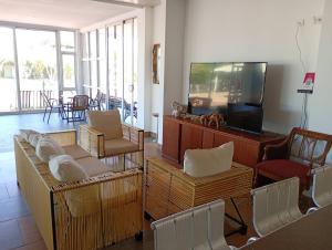 a living room with a tv and a couch and chairs at Astilleros Santa Veronica in Santa Verónica