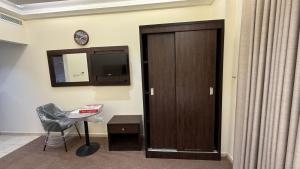 a room with a door and a chair and a clock at فندق مرجانة الحجاز مكة المكرمة in Mecca