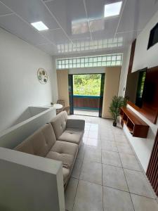 a living room with a couch and a large window at Finch Nest Malecón in San Cristóbal