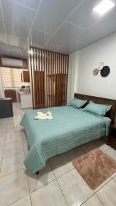 a bedroom with a green bed in a room at Finch Nest Malecón in San Cristóbal