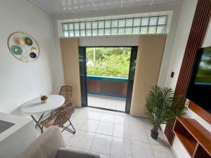 a living room with a table and chairs and a window at Finch Nest Malecón in San Cristóbal