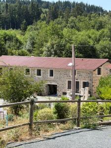 a stone house with a red roof at La chambre du moulin dort in Chénelette