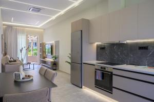 a kitchen with a table and a dining room at Argiri Apartments & Suites in Georgioupolis