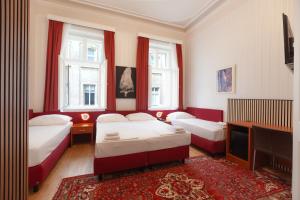 a bedroom with two beds and a tv and windows at HPA Hotel Andreas in Vienna