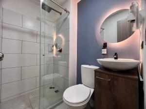 a bathroom with a toilet and a sink and a mirror at Hotel Moore 45 in Medellín