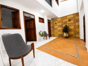 a living room with a chair and a rug at Hotel Boutique Porvenir Real in Charalá