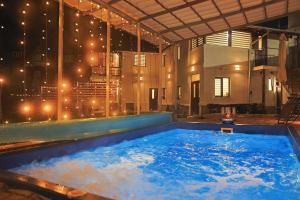 a jacuzzi tub with a view of the city at night at Casa SEMA in Sinaia