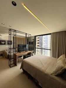 a bedroom with a bed and a desk and a television at Neo House in Maringá +115 photos