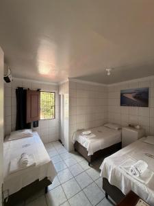 a hotel room with two beds and a bathroom at Hospedaria Maranhense in São Luís