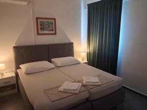 a bedroom with a bed with two towels on it at Zorin House Rooms in Jezera