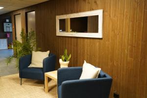 a room with two blue chairs and a window at Birtavarre Aurora Adventures in Birtavarre +33 photos