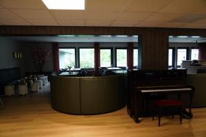 a lobby with a piano and a waiting room at Birtavarre Aurora Adventures in Birtavarre