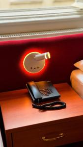 a phone sitting on a table next to a bed at HPA Hotel Andreas in Vienna