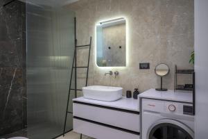 a bathroom with a sink and a washing machine at Argiri Apartments & Suites in Georgioupolis +95 photos