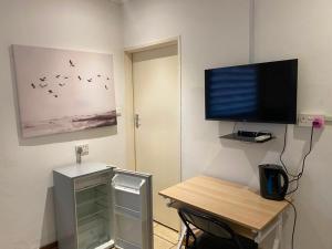 a room with a desk and a television on a wall at Royal Inn Boutique Lodge in Gaborone