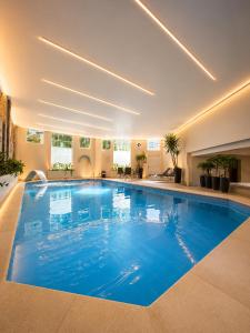 a large swimming pool with blue water in a building at Marambaia Hotel e Convenções in Balneário Camboriú