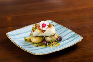 a plate of food with potatoes and a flower on it at Marambaia Hotel e Convenções in Balneário Camboriú +241 photos