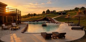 a pool in a resort with chairs and a waterfall at Valle de la Luna in Tandil +93 photos
