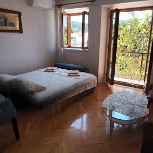 a bedroom with a bed and a couch and a table at Apartment ANDRIUCI in Cavtat