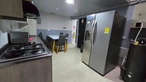 a kitchen with a stove and a refrigerator at aparta hotel continental estadio in Medellín