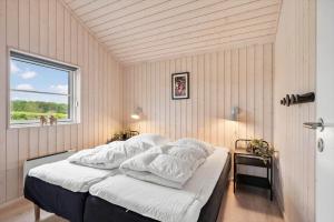 a bedroom with a bed with white sheets and a window at FY416-Frorup-Engparken-10 in Frørup