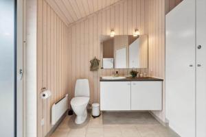 a bathroom with a white toilet and a sink at FY416-Frorup-Engparken-10 in Frørup +20 photos