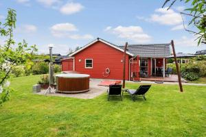 a red house with a hot tub in a yard at FY416-Frorup-Engparken-10 in Frørup