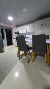 a dining room with two chairs and a table in a kitchen at aparta hotel continental estadio in Medellín +25 photos