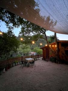 a patio with a table and chairs under a tree at RVilla in Pavliani