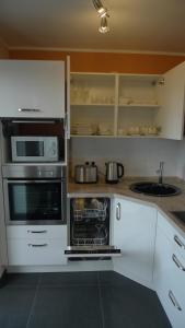 a kitchen with white cabinets and an open oven at Luxusappartement in Meerbusch