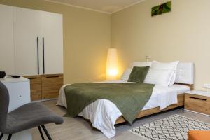 a bedroom with a bed with a green blanket and a chair at Casa SEMA in Sinaia +62 photos