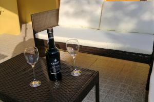a bottle of wine sitting on a table with two wine glasses at The Yellow House in Vila Nova de Gaia