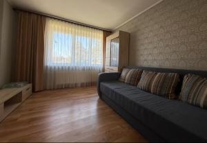 a living room with a couch and a large window at Omes puurs in Ventspils +1 photo