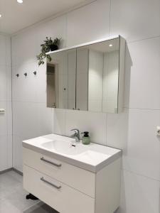 a white bathroom with a sink and a mirror at Leknestunet in Vestvågøya +24 photos