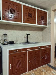 a kitchen with brown cabinets and a sink at Casa Cariño in San Cristóbal de Las Casas