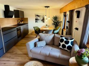 a living room with a couch and a kitchen at Hof Wälderblick in Ibach