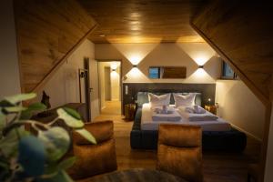 a bedroom with a bed and chairs in a room at SAUERLAND CHALETS - "Die Chalets Lieblingsplatz" in Winterberg