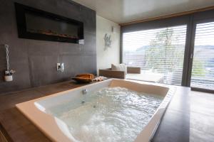a large bath tub in a bathroom with a living room at SAUERLAND CHALETS - "Die Chalets Lieblingsplatz" in Winterberg +54 photos