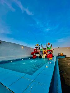 a pool with two lifeguard chairs and a swimming pool at شقق ارين المصيف للشقق المخدومة in Al Hada