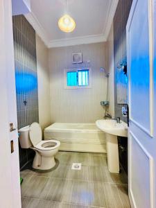 a bathroom with a toilet and a tub and a sink at شقق ارين المصيف للشقق المخدومة in Al Hada