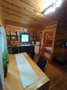 a dining room with a table and a television in a cabin at Sosnowy Domek in Wólka