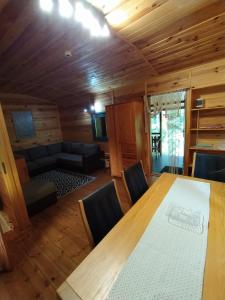 a dining room with a table and a couch at Sosnowy Domek in Wólka