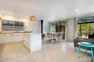 a kitchen and living room with a couch and a table at The River House - Wisemans Ferry in Wisemans Ferry +20 photos