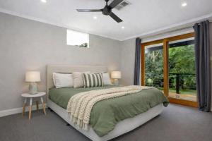 a bedroom with a bed and a window at The River House - Wisemans Ferry in Wisemans Ferry