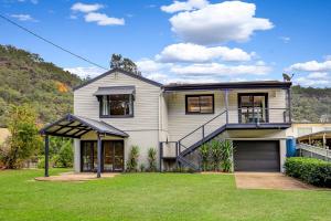 a large white house with a large yard at The River House - Wisemans Ferry in Wisemans Ferry