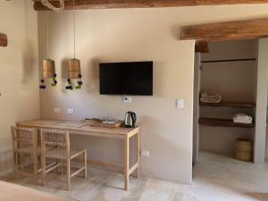 a room with a desk and a tv on a wall at Aguacanto Cabañas in Tilcara