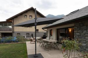 a patio with a table and an umbrella at L'Entre Nous Climatisation Terrasse in Saint Avre la Chambre