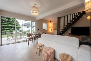 a living room with a couch and a table with chairs at L'Entre Nous Climatisation Terrasse in Saint Avre la Chambre
